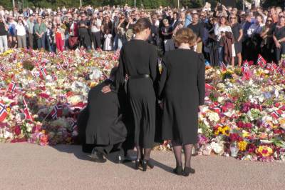 Kongefamilien legger ned blomster på Slottsplassen